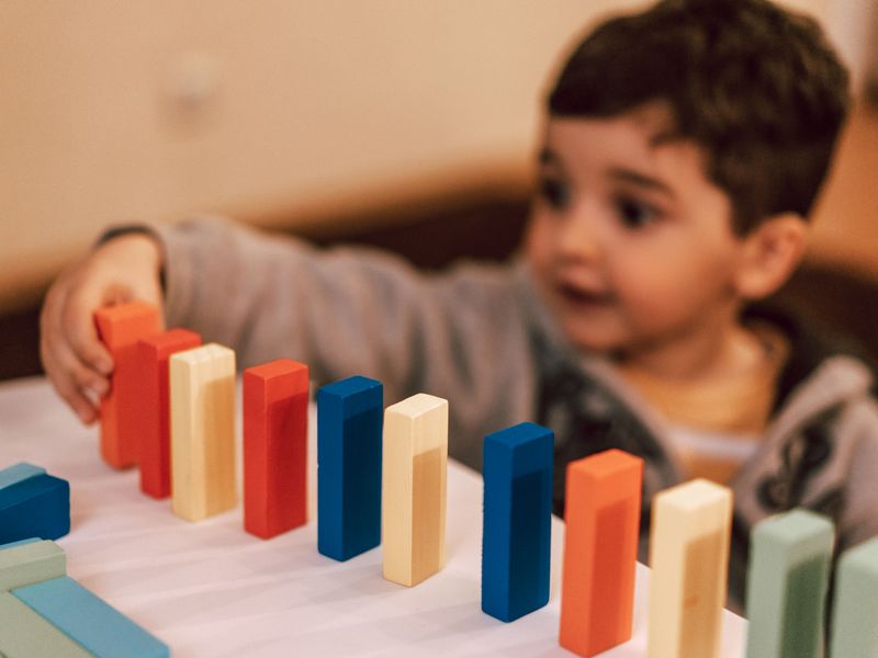 Child focused on colourful wooden blocks